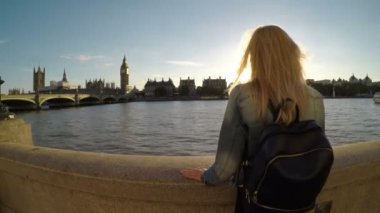 Genç kadının Big Ben ve Londra'da Thames Nehri yakınlarındaki Sarayı gezisi