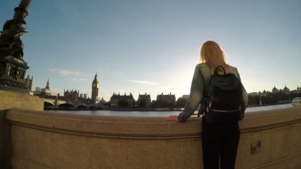 Attraktive Frau, die Londons große Stadt und das Parlament in der Nähe der Themse besichtigt — Stockvideo