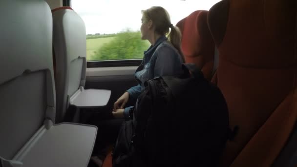 Zamyšlený dospívající dívka samostatně cestující ve vlaku, relaxační a dívat se skrz okno těší venkovské krajiny — Stock video