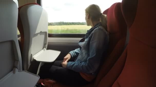 Treno passeggero donna in viaggio guardando fuori dalla finestra verdi colline e alberi sullo sfondo — Video Stock