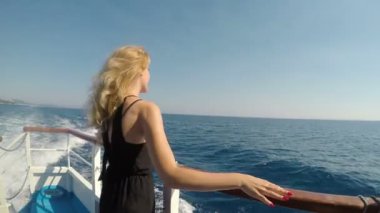 Mutlu genç kadın gülümseyerek ve dalgalar hayran denizde seyahat cruise gemi tatil