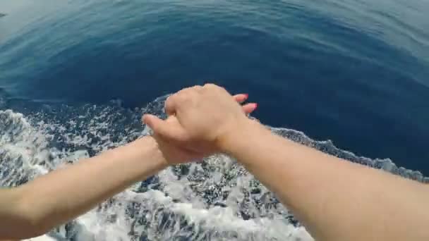 Ponto de vista do jovem casal apaixonado mãos alegres enquanto viaja em um navio de cruzeiro sobre o mar — Vídeo de Stock