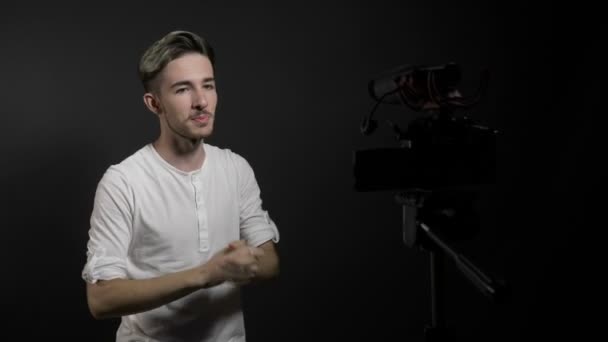 Jeune adolescent heureux et joyeux vidéo de tir vlogger masculin avec caméra professionnelle remerciant les fans pour leur soutien — Video