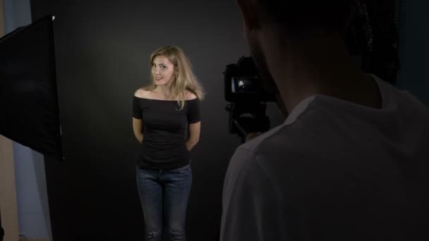 Jonge cameraman opname een aantrekkelijke jonge mooie vrouw praten met de camera voor een nieuwe aflevering van haar video vlog — Stockvideo