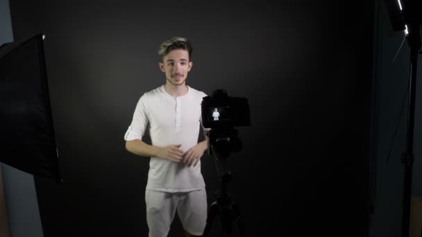 전문 스튜디오에서 그의 vlog에 대 한 비디오를 기록 하는 동안 웃는 젊은 남자 geturing — 비디오