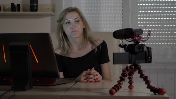 Όμορφη νεαρή ξανθιά επαγγελματίες vlogger γυναίκα κάθεται στο γραφείο της και μαγνητοσκόπηση ένα βίντεο πώς να φροντιστήριο για vlog της — Αρχείο Βίντεο