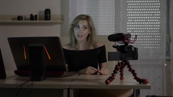 Blonde aantrekkelijke vrouwelijke video blogger zelf filmen met een camera op Bureau onderwijs publiek analyseren van verkeersgegevens — Stockvideo