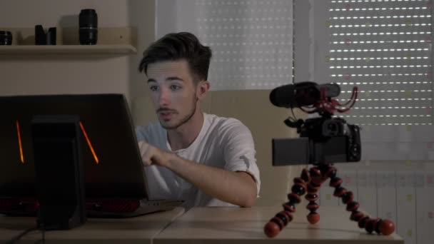 Junge männliche Video-Vlogger filmt sich selbst mit einer Kamera im Büro lehrt Publikum, wie man ein Online-Blog zu starten — Stockvideo