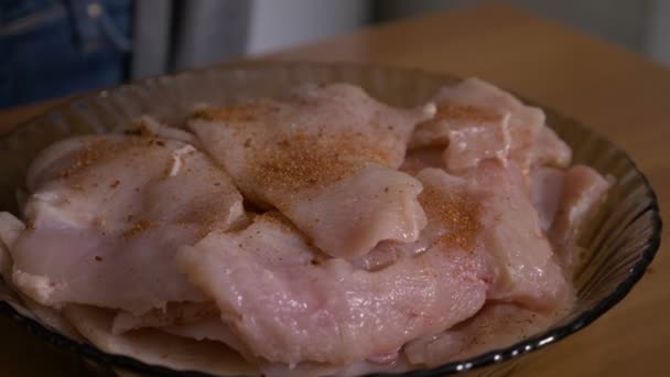 Primer plano de la joven cocinera sazonando carne de pollo en rodajas con especias y aceite — Vídeos de Stock