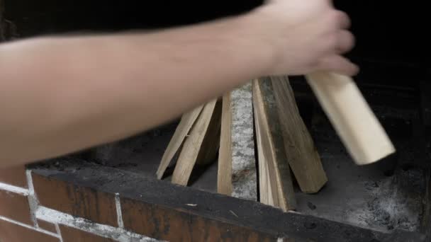 Hombre adolescente preparando los palos de madera en la parrilla de barbacoa — Vídeos de Stock