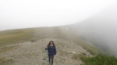 Uzun yürüyüşe çıkan kimse genç kadın turist arka planda sis ile yolda dağlar ilgi çekici yerlerini keşfetmek için yürüyüş