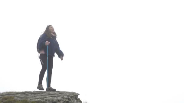 Bem-sucedida menina alpinista feliz na expedição celebrando a realização de alcançar o topo da montanha enevoado levantando mãos — Vídeo de Stock