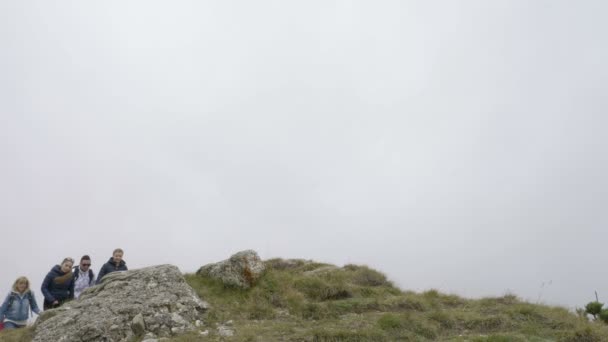 一群年轻的徒步旅行者带着背包站着, 双手攀上登山冠军的山顶概念 — 图库视频影像