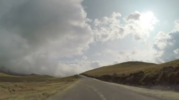 Rychlý timelapse akční jízdy auto na zakřivení trasy s kopci a zamračená obloha na horu toppov — Stock video