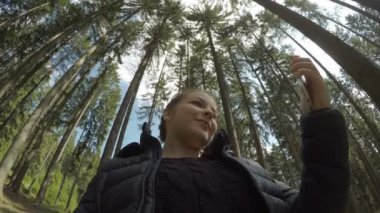 Şirin bin yıllık kadında rahatlatıcı bir ormanı selfie fotoğraf çekim için smartphone telefon kullanarak