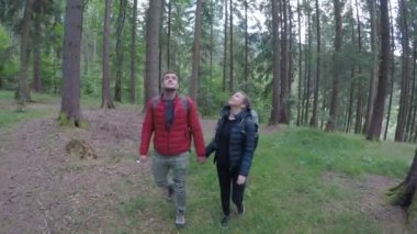 Çift el ele tutuşarak ormanda hiking sırt çantaları ile teen güzel yürüyüşçü
