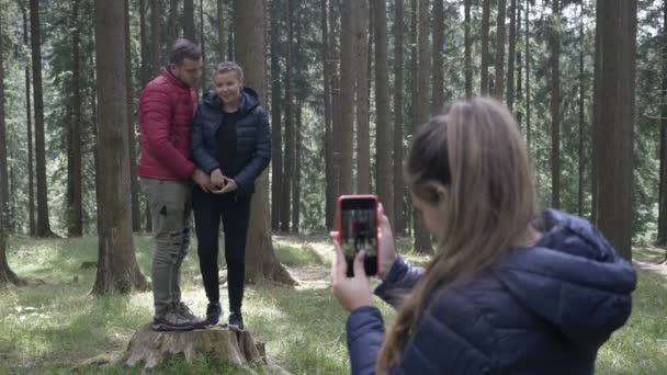 Adolescente donna scattare foto con la fotocamera del suo smartphone per una giovane coppia escursioni nel bosco — Video Stock