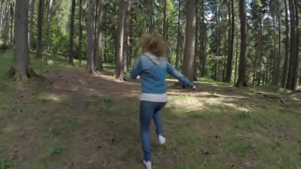 Φοβισμένη νεαρή κοπέλα τρέχει μακριά για να ξεφύγουν από τον κίνδυνο μέσα από το δάσος στο βουνό — Αρχείο Βίντεο