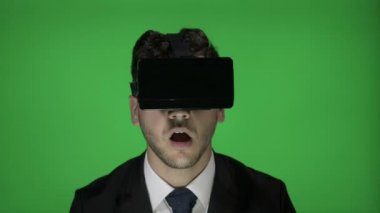 Korkunç bir film römork üzerinde yeşil ekran arka planı süre tarassut genç iş adamı sanal gerçeklik gözlüğü kulaklık ile titredi