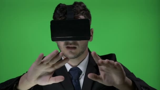 Счастливый молодой человек носит официальный костюм с 3D vr очки для прокрутки и печатать в киберпространстве на зеленом фоне экрана — стоковое видео