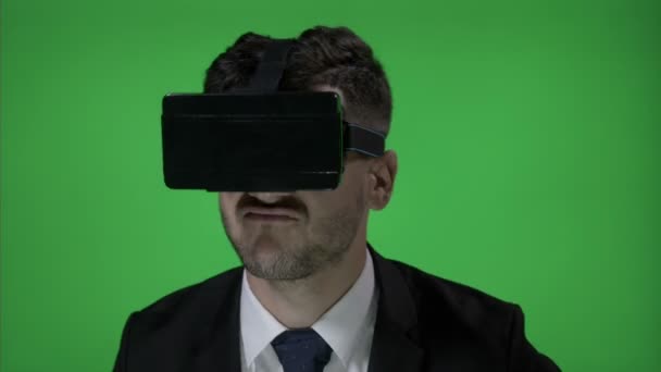 Jonge man genieten van een geweldige tijd tijdens het gebruik van de futuristische technologie met een Vr bril kijken muziekvideo's en dans op groen schermachtergrond — Stockvideo