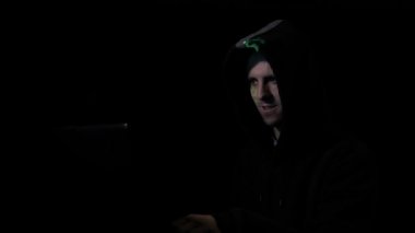 Karanlık bitcoin para birimi sunucularda ticaret oturan ve yüzünde sembolü yansıtılır süre telefonda konuşuyor hood siber suç