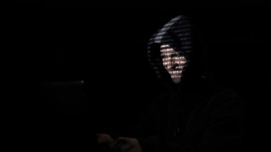 Kötü hacker'kukuleta çalışkan kodu yüzünde yansıtılır ise karanlık bir odada evden bir virüs oluşturmak için