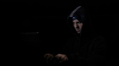 Kızgın endişeli hacker bilgisayar programcısı siber güvenlik sunucuları saldıran ve dijital veri yüzünde yansıtılır iken başını sallayarak Hood