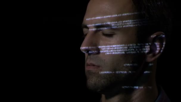 Nahaufnahme von ai Software-Entwickler Mann mit Bart hält die Augen geschlossen und bewegt seinen Kopf, während der Programmiercode auf seinem Gesicht reflektiert wird — Stockvideo