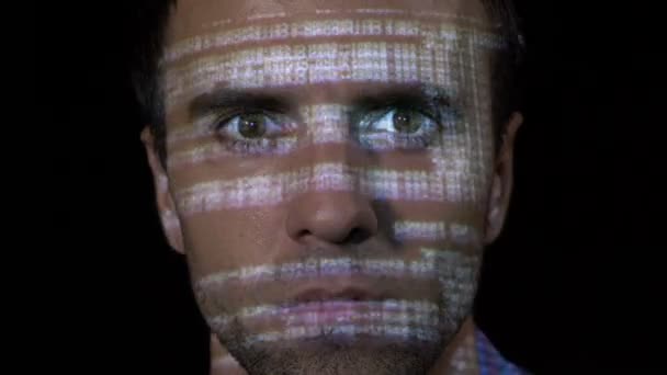 Портрет молодого программиста-кибер-работника мужчины, работающего над антивирусной программой, в то время как код проецируется на его лицо — стоковое видео