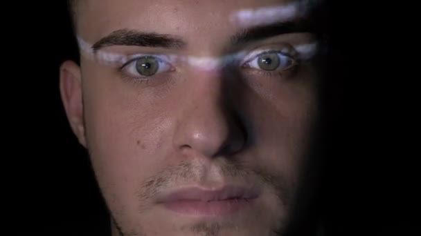 Retrato de un adolescente brillante con ojos verdes viendo el proceso de hacking en la pantalla mientras el código se refleja en su cara — Vídeo de stock