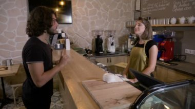 Genç adam bir kahve dükkanı girme ve gitmek için bir mocha latte kafe sipariş ve temassız kart ile ödeme