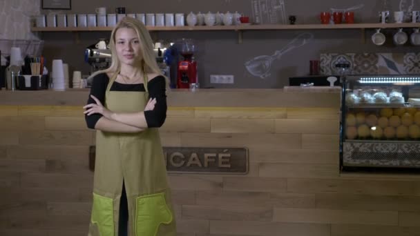 Ciężko pracujący młoda blond kobieta wreszcie otwiera własną działalność kawiarni i stoi dumnie przed licznik z ramionami skrzyżowane i uśmiechając się — Wideo stockowe