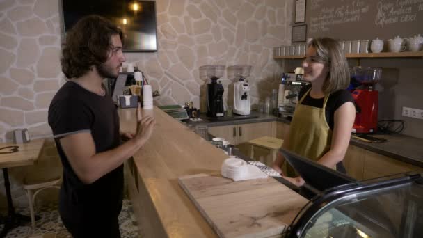 En mann går inn i en kaffebar og bestiller en cappuccino for å betale den med appen krypto mynt – stockvideo