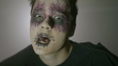 Garip gözleri ve yüz boyama korkunç Cadılar Bayramı yapıyor bir genç psikopat zombi adam portresi taşır