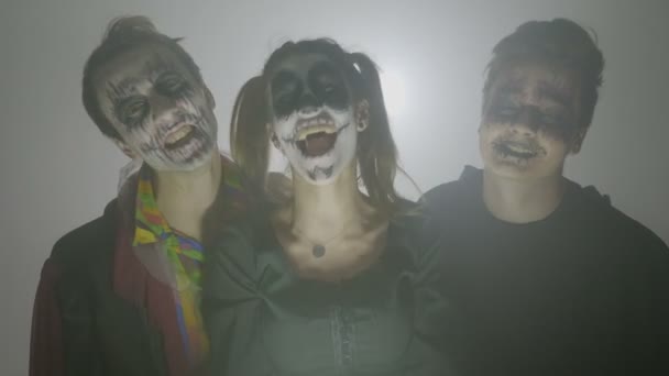 Retrato de un grupo de tres zombis riendo locos en una noche de niebla planeando asustar a la gente en el día de Halloween — Vídeos de Stock