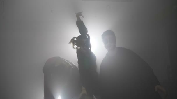 Отряд зомби на Хэллоуин, идущий из тумана в деревню, пугает людей в замедленной съемке — стоковое видео