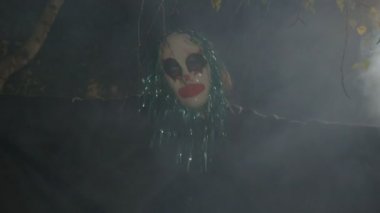 Dans eden bir ölüm ritüel ve kötü performans duman dışında karanlıkta oturup Halloween korku palyaço gülüyor