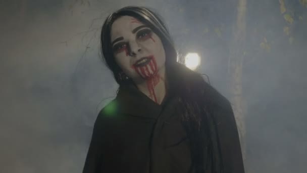 Maldita vampira fêmea malvada desfrutando da noite de Halloween nebulosa na floresta e rindo — Vídeo de Stock