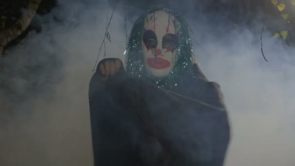 Malefic halloween zabawny clown noszenie maski i zielone włosy fałszywe wykonywanie zła tańca w ciemnym lesie — Wideo stockowe