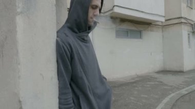 Genç uyuşturucu satıcısı keş bir ot sigara ve uyuşturucu paketi iyi nakit para karşılığında alması istemci bekleyen Hood