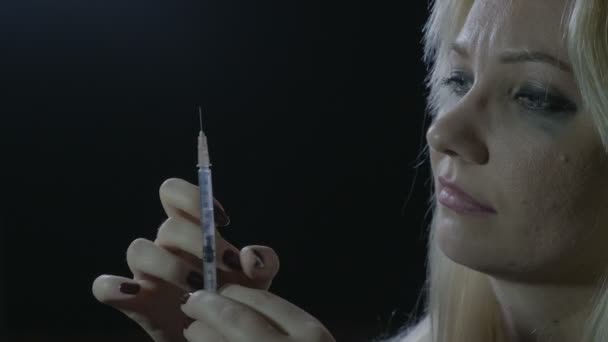 Porträtt av en ung kvinna som förbereder sprutan med heroin att överträffa depression hemma i ett mörkt hörn av rummet — Stockvideo