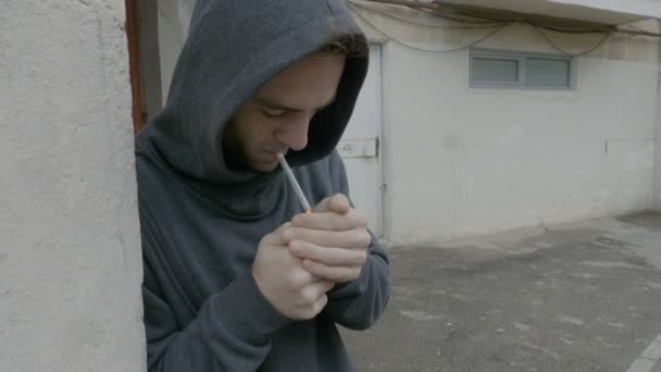 Junkie, ein junger männlicher Student, raucht hinter den Blöcken Unkraut und verkauft Marihuana diskret an einen Kunden — Stockvideo