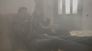 Ivır zıvır erkek bir uyuşturucu evi duman tam süre teneffüs edilmesi ve bir paylaşılan esrar eklemi exhaling oturma odasında vurguladı