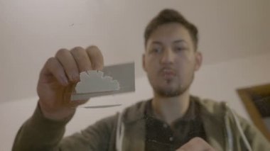 Şeffaf cam masa evde üzerinde kalın bir kart ile kokain toz kazıma bir narkotik delikanlı portresi