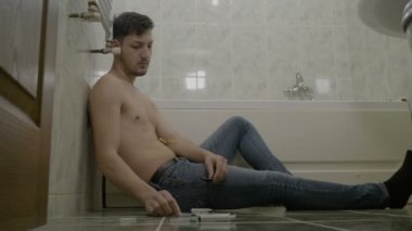 Onun günlük doz eroin banyoda Isıtma ve sonra yerde yatarken damarları enjekte atletik iyi görünümlü profesyonel spor oyuncu adam