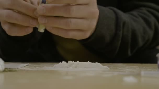Крупным планом юного отца, нюхающего кокаин со стола, пока его жены и детей нет дома. — стоковое видео