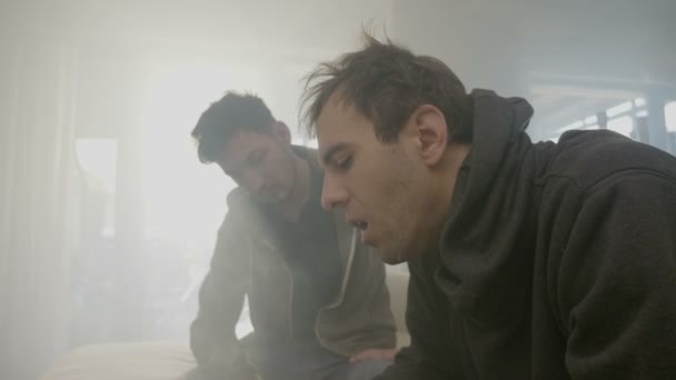 Teneffüs edilmesi ve daire içinde sigara paylaştıktan sonra ortak bir esrar duman exhaling çocuklar tüketiciler genç uyuşturucu bağımlısı — Stok video