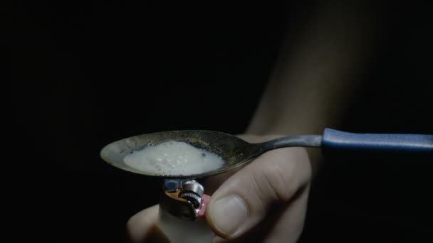 Close up van een man drug consument verwarming heroïne met behulp van een lepel en lichter en vervolgens bereiden zijn schot — Stockvideo