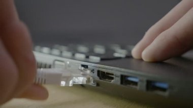 Bir erkek el bağlanma ve ağ bağlantıları onarmak için onun laptop Internet beyaz kablo kesme yakın çekim